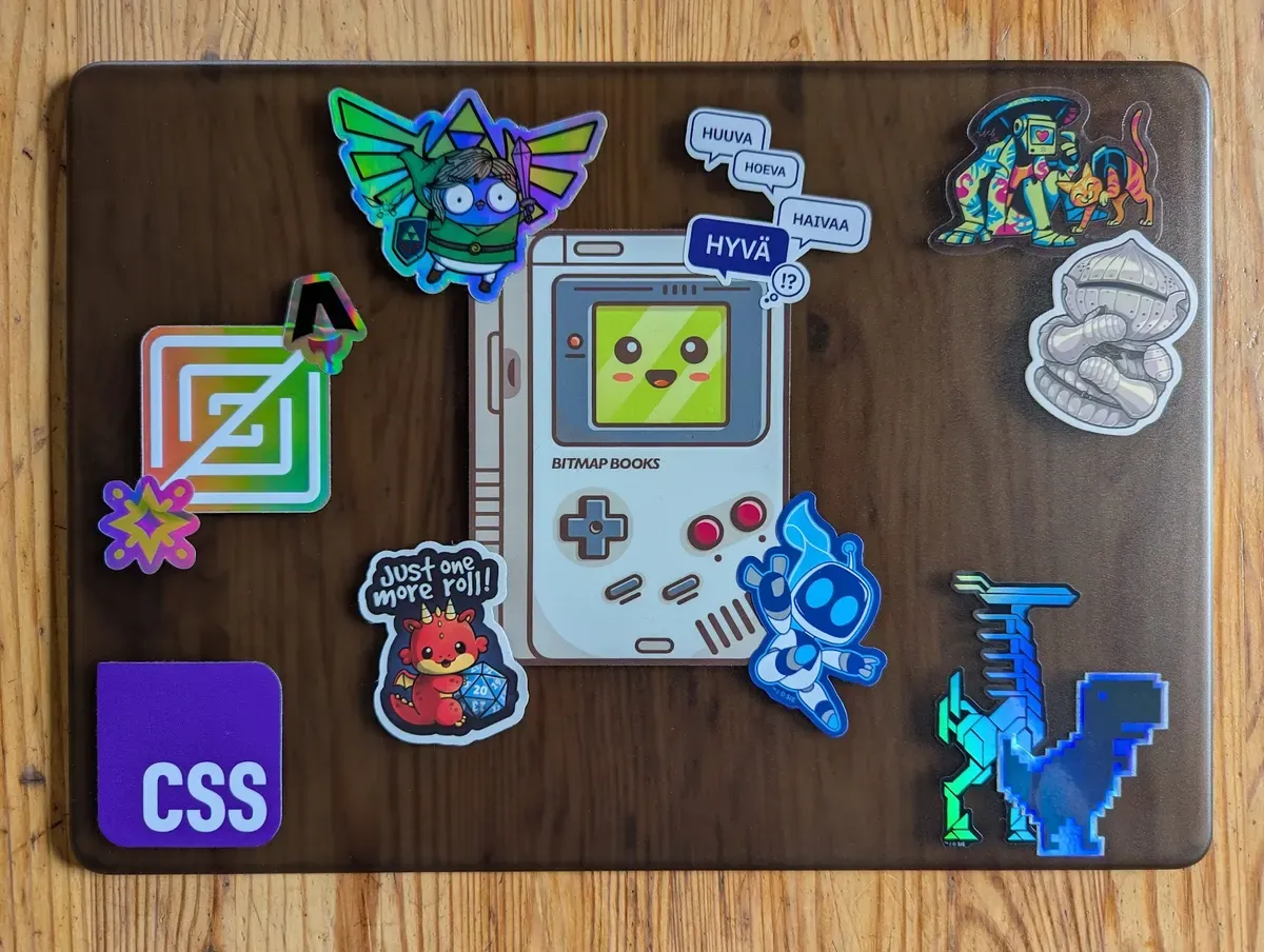 Translucent laptop cover with stickers, among them the CSS logo, Zed, Astro, a Game Boy, Astro Bot, the Chrome dino and a Hyvä speech bubble
