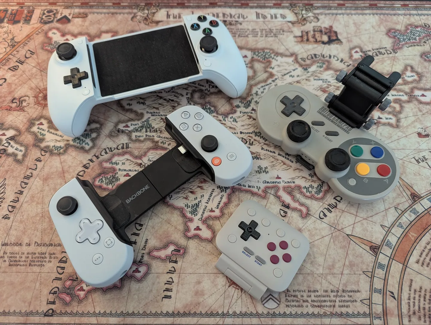 My phone controllers, from top left to bottom right: 8BitDo Ultimate Mobile Gaming Controller, 8BitDo Phone Grip with the 8BitDo SN30 Pro+, Backbone and the 8BitDo FlipPad
